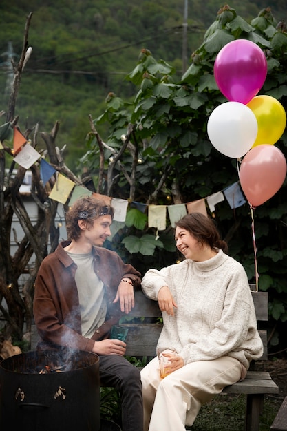 Photo gratuite vue latérale des gens souriants bavardant à l'extérieur