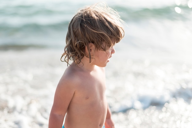 Vue latérale, de, gosse, regarder loin, à, les, plage