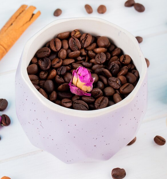 Vue latérale des grains de café dans un bol sur fond blanc