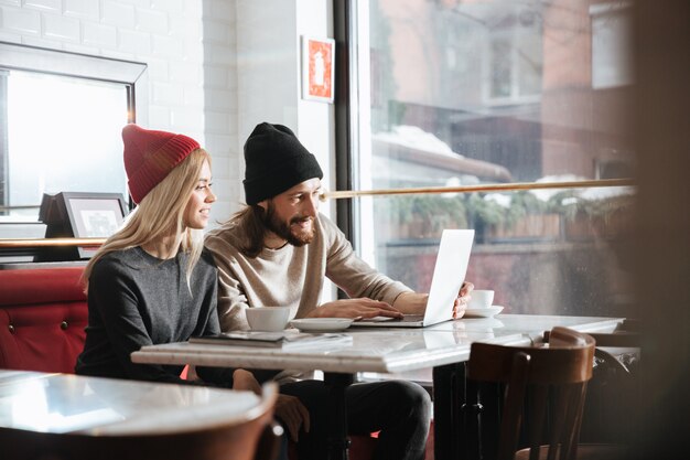 Vue latérale des hipsters avec ordinateur portable