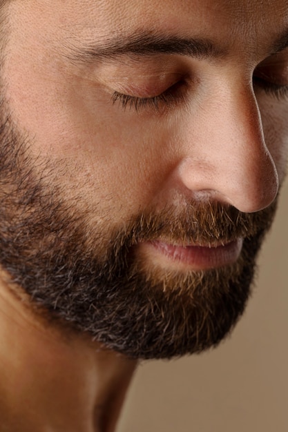 Vue latérale homme avec barbe posant
