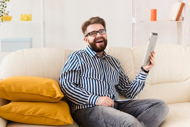 Vue latérale de l'homme sur le canapé avec tablette