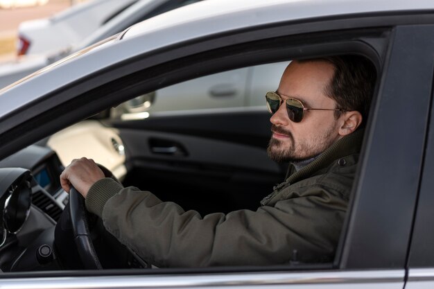 Vue latérale homme conduisant une voiture