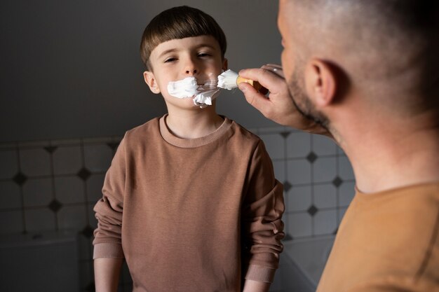 Vue latérale homme enseignant à un enfant comment se raser