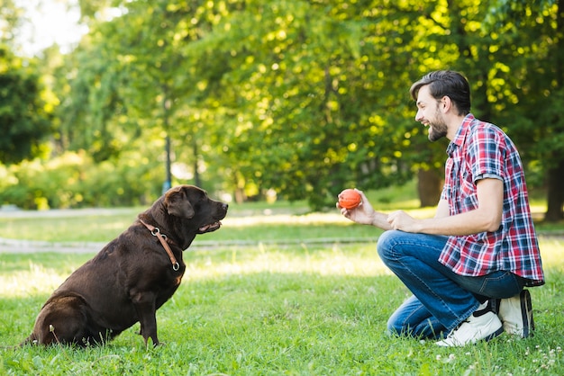 Vue latérale d&#39;un homme heureux jouant avec son chien