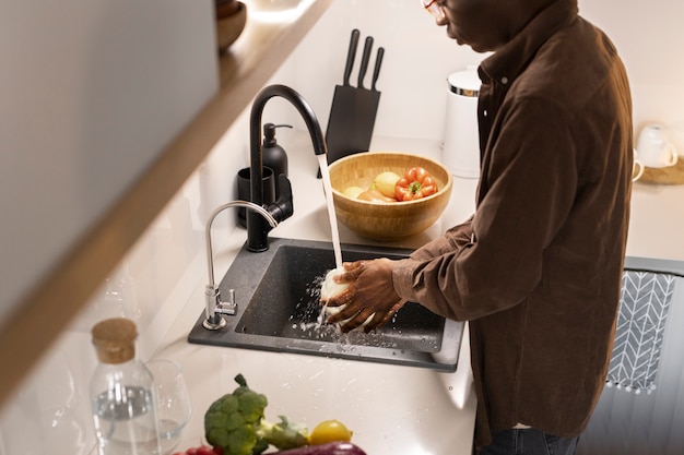 Photo gratuite vue latérale homme lavant des légumes