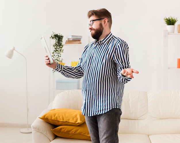 Photo gratuite vue latérale de l'homme à la maison avec tablette