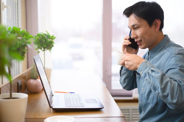 Vue latérale homme parlant au téléphone