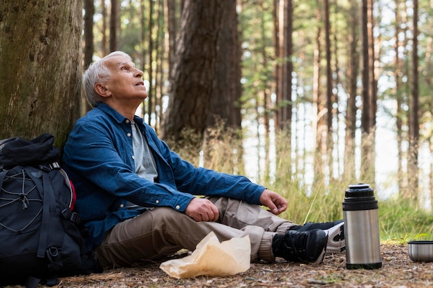 Vue latérale d'un homme plus âgé au repos lors d'un voyage à l'extérieur