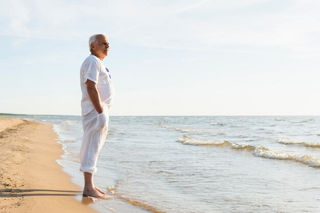 Vue latérale d'un homme plus âgé profitant de la vue sur la plage