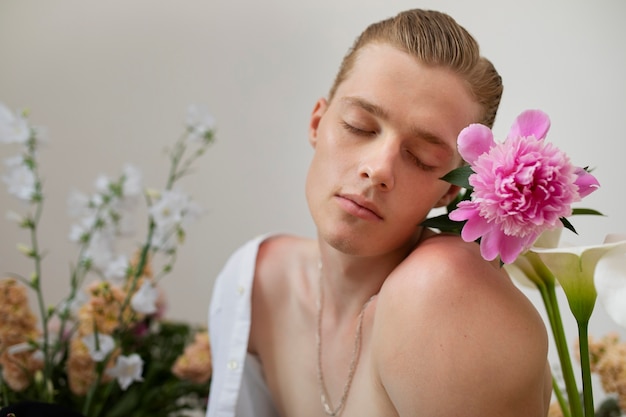 Vue latérale homme posant avec des fleurs
