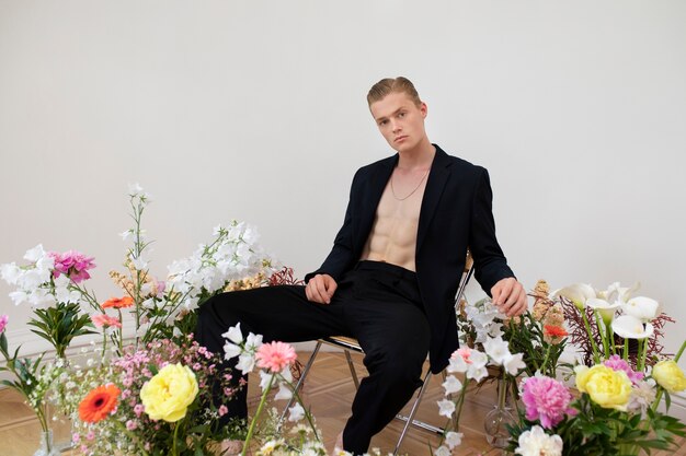 Vue latérale homme posant avec des fleurs