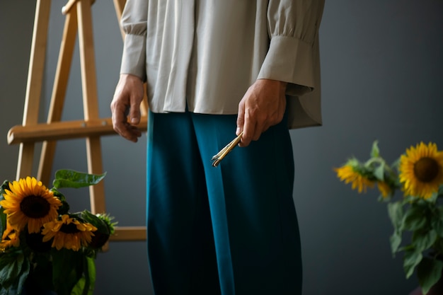 Vue latérale homme posant avec des tournesols