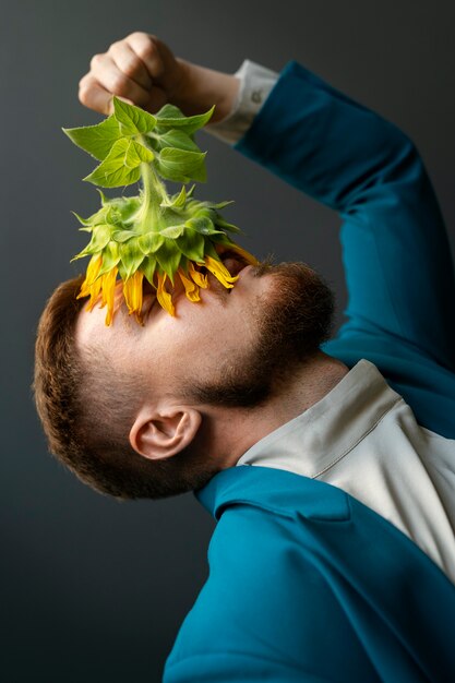 Vue latérale homme posant avec des tournesols