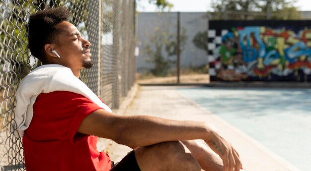 Vue latérale de l'homme prenant une pause après un match de basket