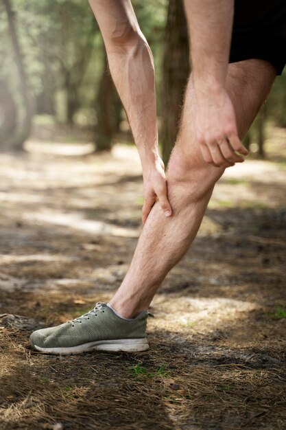 Vue latérale homme qui s'étend de la jambe à l'extérieur