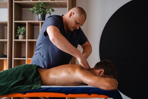 Vue latérale homme recevant un massage professionnel