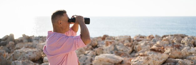 Vue latérale homme regardant à travers des jumelles