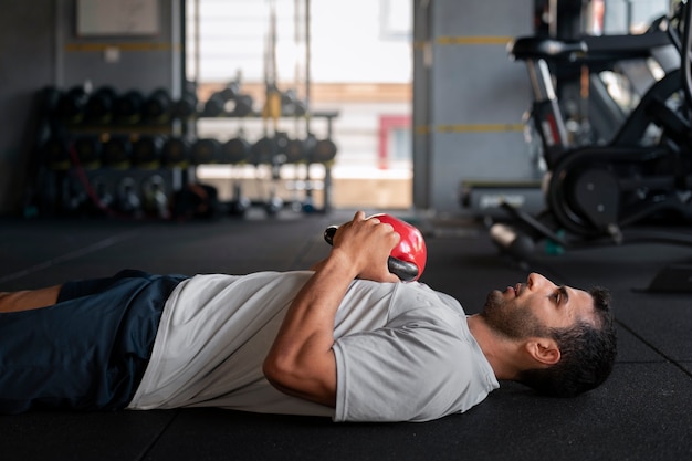 Vue latérale homme s'entraînant avec kettlebell