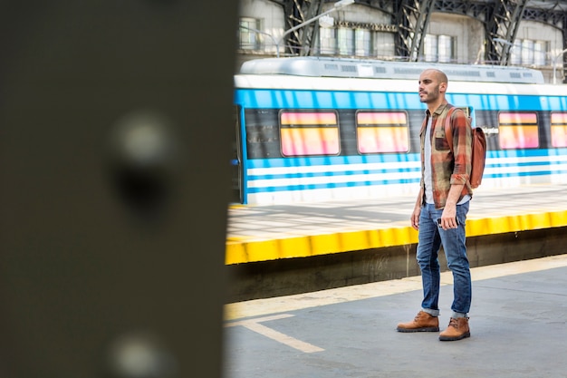 Vue latérale homme avec sac à dos voyageant