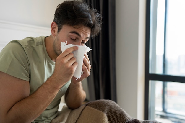 Photo gratuite vue latérale homme se moucher