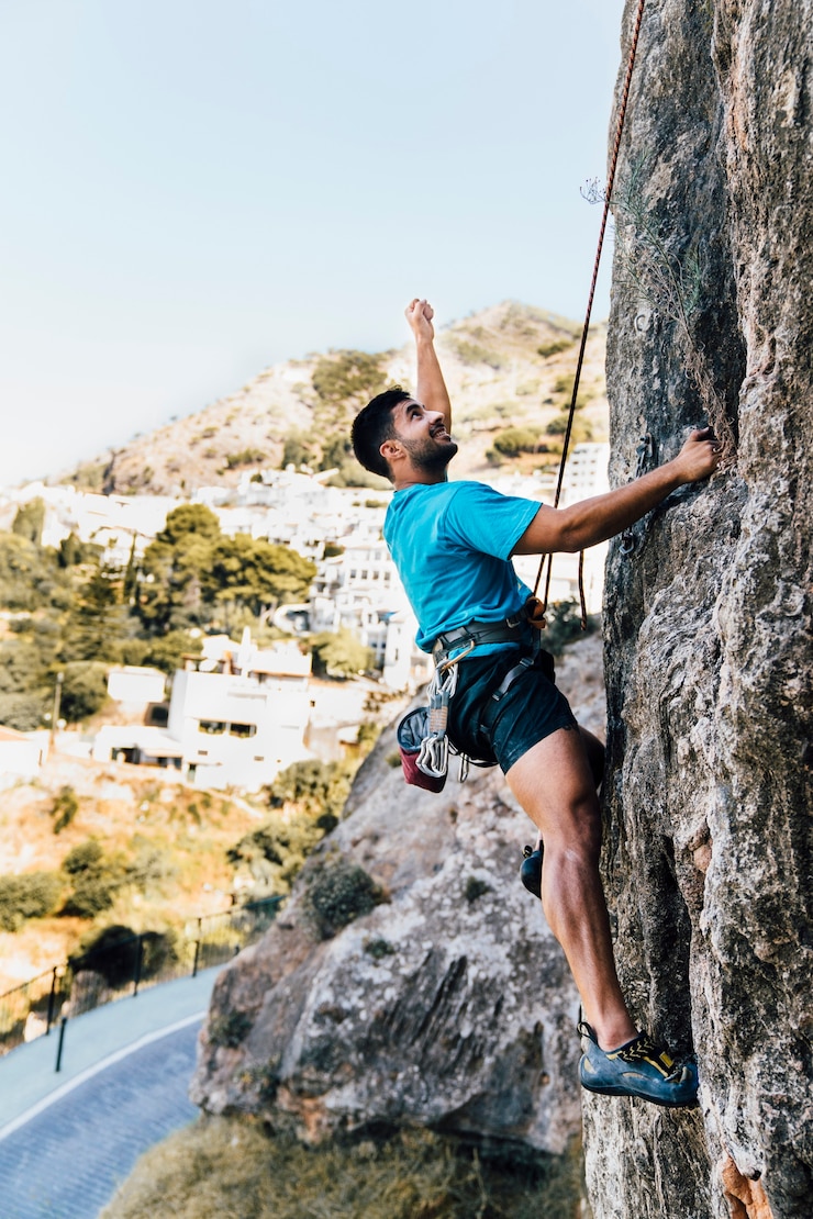 Photo gratuit vue latérale de l&#39;homme sportif qui monte sur le rock