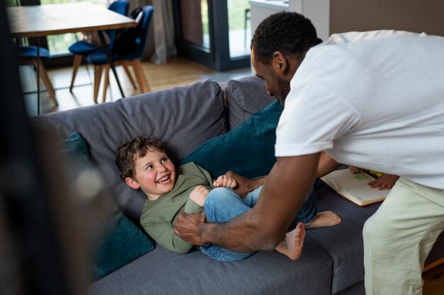 Vue latérale homme tenant un enfant souriant