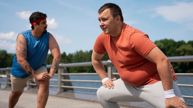 Vue latérale des hommes exerçant ensemble à l'extérieur