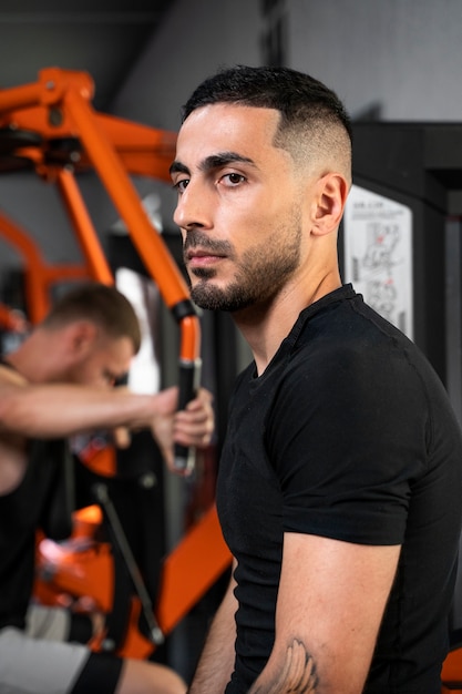 Photo gratuite vue latérale des hommes s'entraînant au gymnase