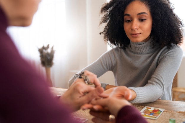 Photo gratuite vue latérale jeune femme lisant le tarot