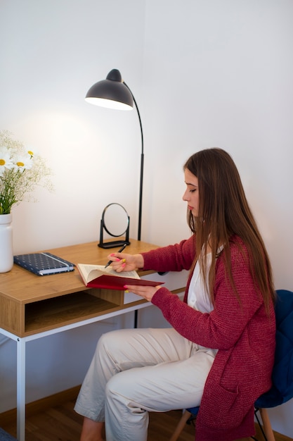 Photo gratuite vue latérale d'une jeune femme qui passe du temps à la maison