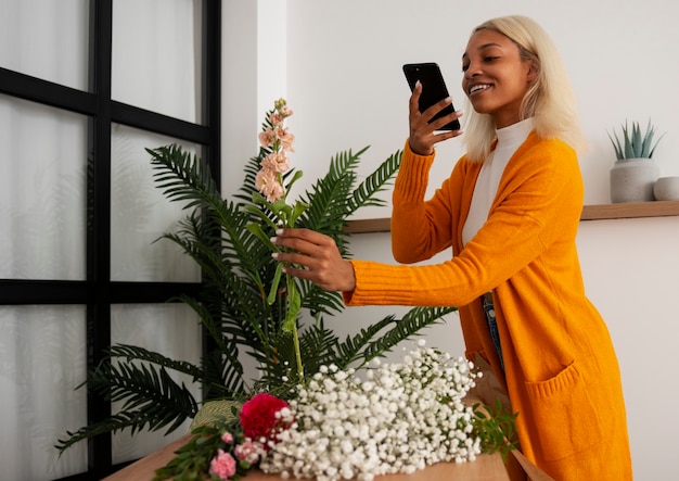 Photo gratuite vue latérale d'une jeune femme qui s'occupe des plantes