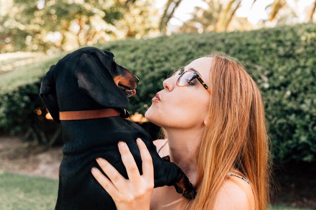 Vue latérale d&#39;une jeune femme avec son chien dans le parc