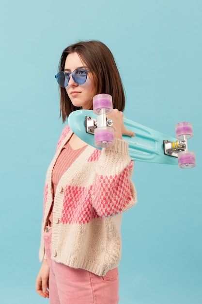 Photo gratuite vue latérale jeune fille avec planche à roulettes