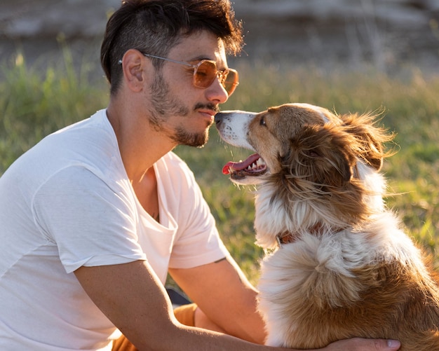 Vue latérale jeune homme avec chien au bord de la mer