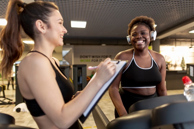 Photo gratuite vue latérale des jeunes femmes au gymnase