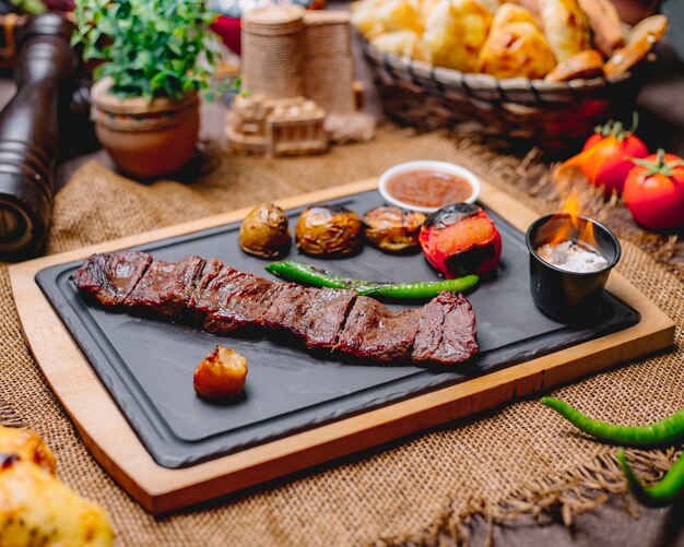 Vue latérale langet de viande rôtie avec pommes de terre et légumes grillés avec sauces