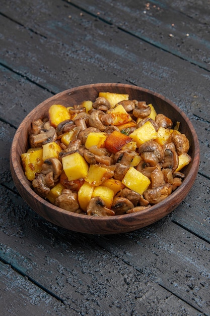 Vue latérale de loin assiette avec pommes de terre alimentaires et champignons dans l'assiette au centre de la table