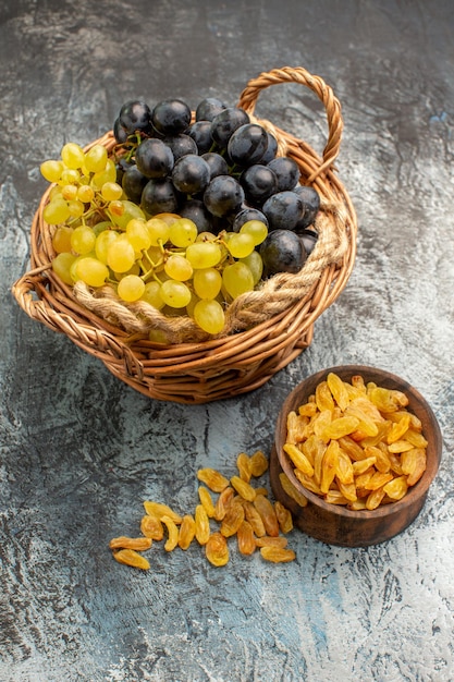 Vue latérale de loin fruits le panier avec des raisins brun bol de fruits secs