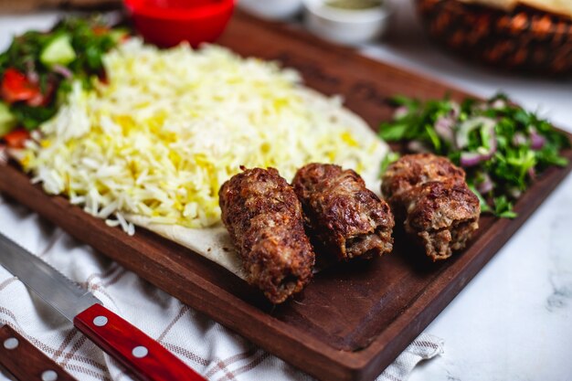 Vue latérale lula kebab avec riz et oignon