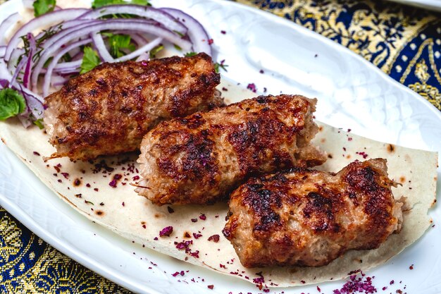 Vue latérale lulya kebab avec des oignons verts et de l'épine-vinette séchée sur pita