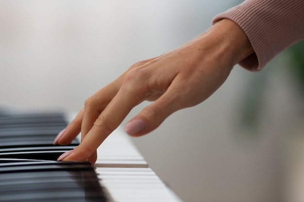 Vue latérale main jouant du piano