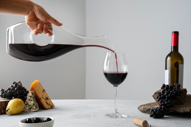 Photo gratuite vue latérale main verser du vin dans un verre