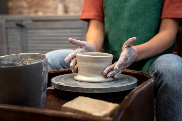 Vue latérale des mains faisant de la poterie