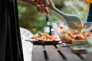 Photo gratuite vue latérale des mains mélangeant la salade