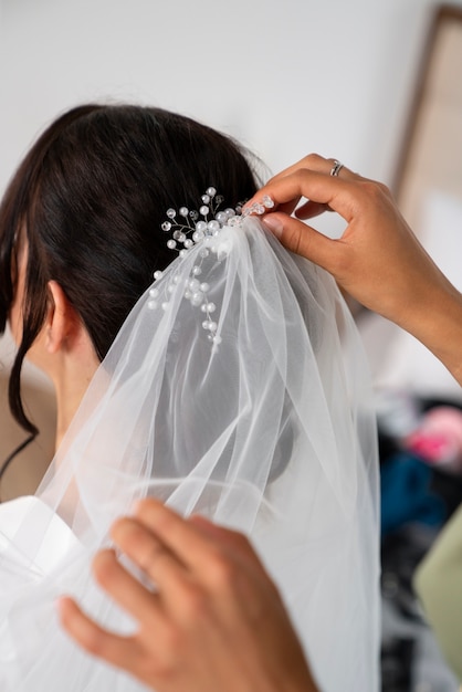 Photo gratuite vue latérale des mains organisant le voile de mariée