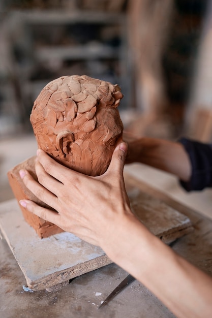 Photo gratuite vue latérale mains sculpture d'argile