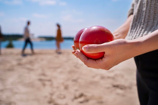 Vue latérale mains tenant des boules rouges