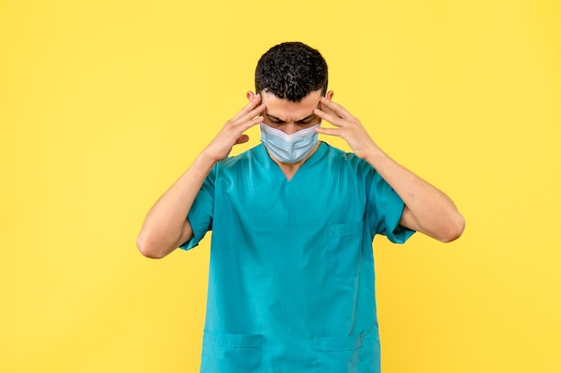 Vue latérale d'un médecin en masque dans l'uniforme médical bleu a mal à la tête