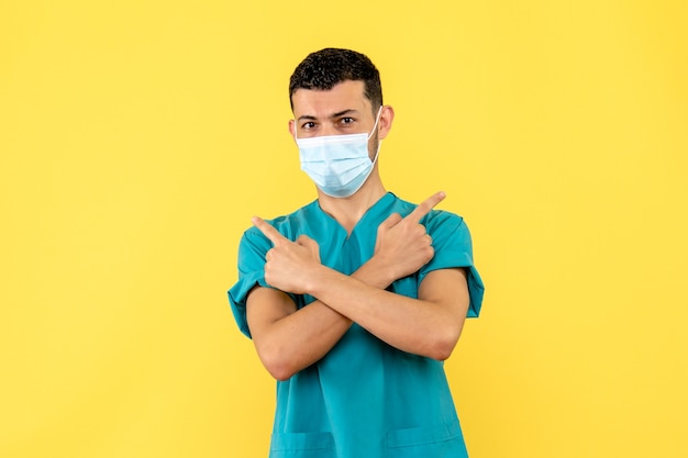 Vue latérale d'un médecin un médecin avec masque dans l'uniforme médical sur le fond jaune